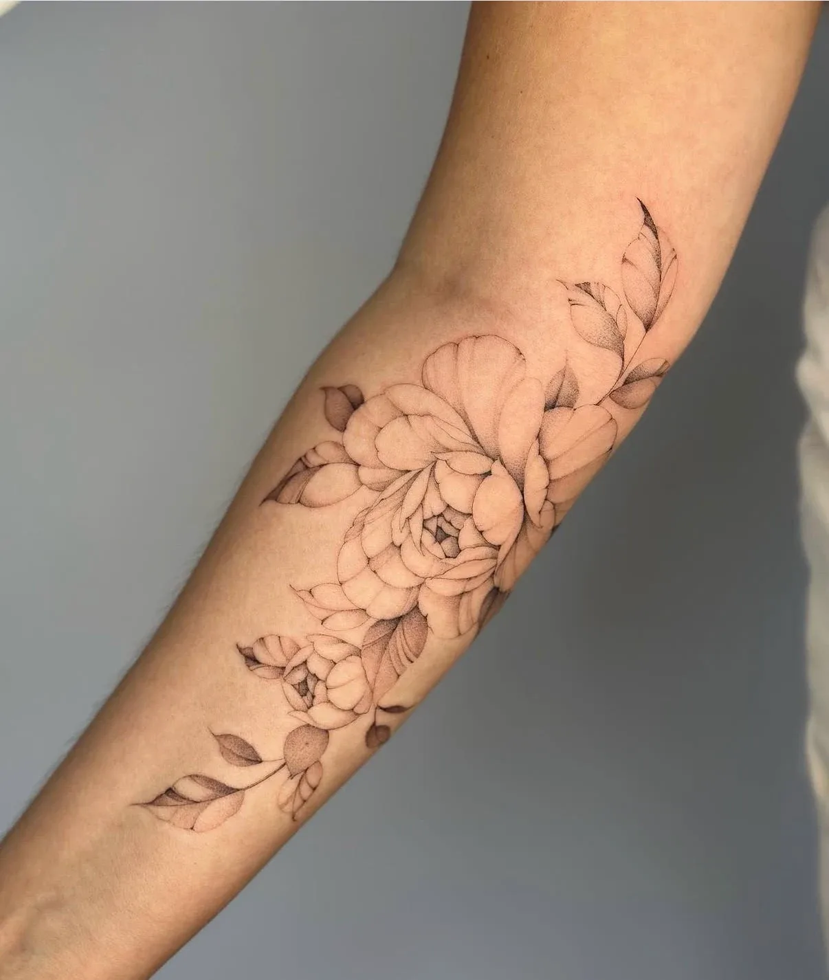 Florales Tattoo mit feinen Linien und Schattierungen am Arm – Arbeit von Maxim