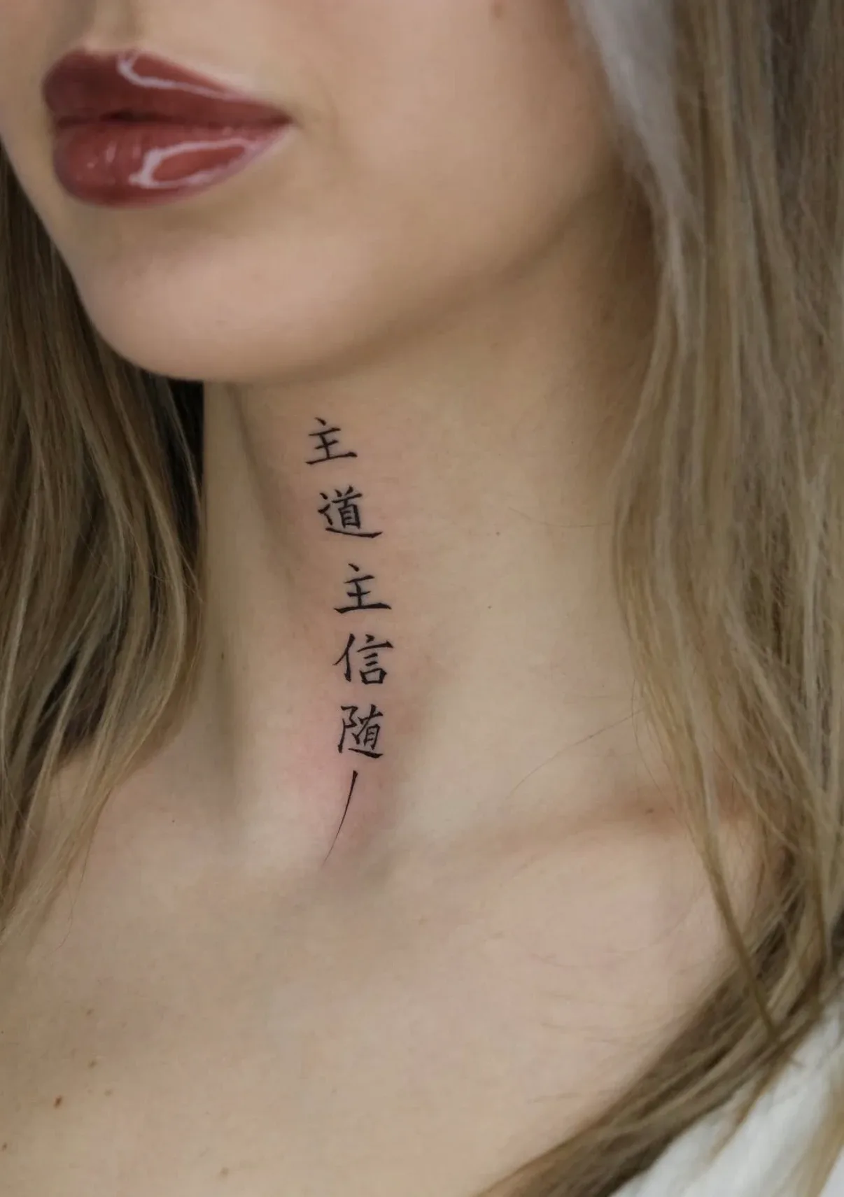 Senkrechte Schriftzeichen als Tattoo am Hals – Arbeit von Maxim