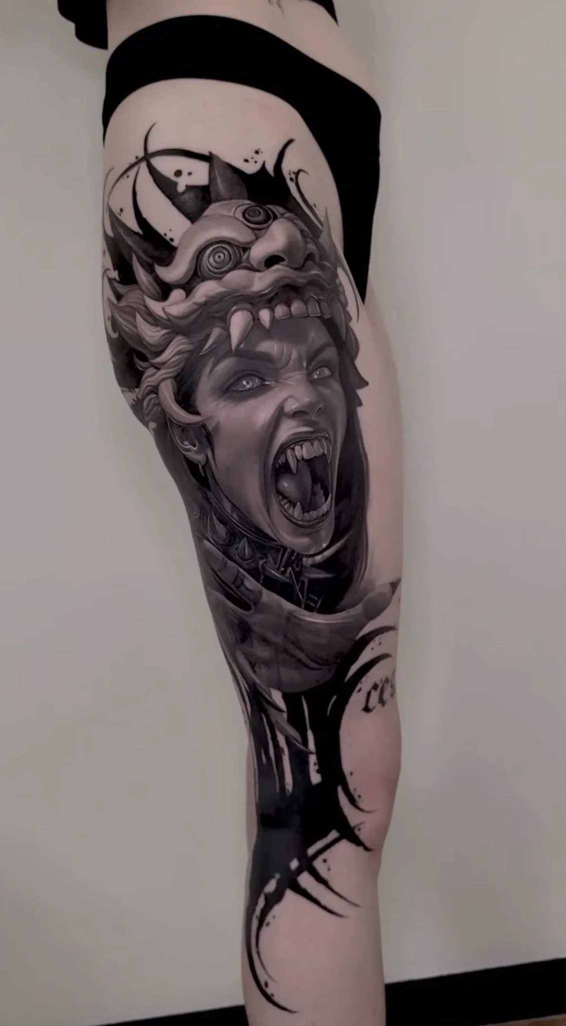 Dark-Art-Tattoo von Ruby mit dämonischem Frauenporträt, gehörnter Maske und schwarzen grafischen Elementen
