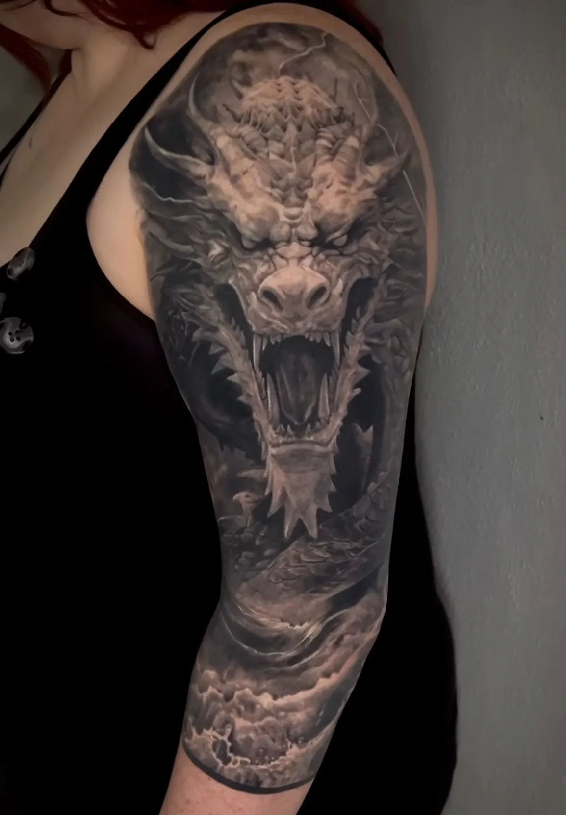 Black-and-Grey-Drachentattoo von Ruby mit Wolken am Arm